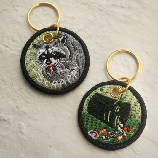 Scrappy Raccoon Double-Sided Embroidered Keychain.